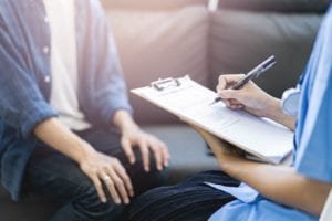 Nurse marks paperwork on clipboard