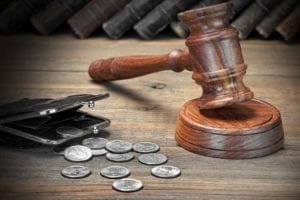 Gavel and wallet with coins spilling out 