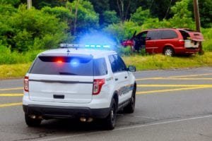 Police flashing blue lights at accident damaged car