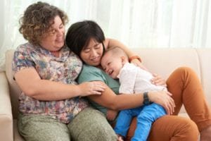 Lesbian couple resting on sofa with their son