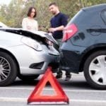 Two drivers examining car body damages after rear end accident