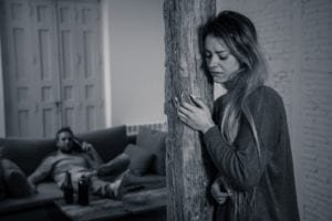 Woman crying while a man sits on the couch