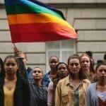 LGBTQ community with pride flag on city street