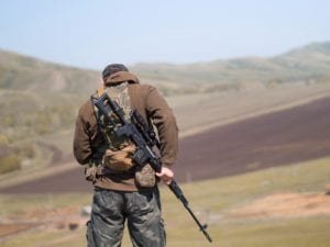 Man in military uniform holding a sniper rifle