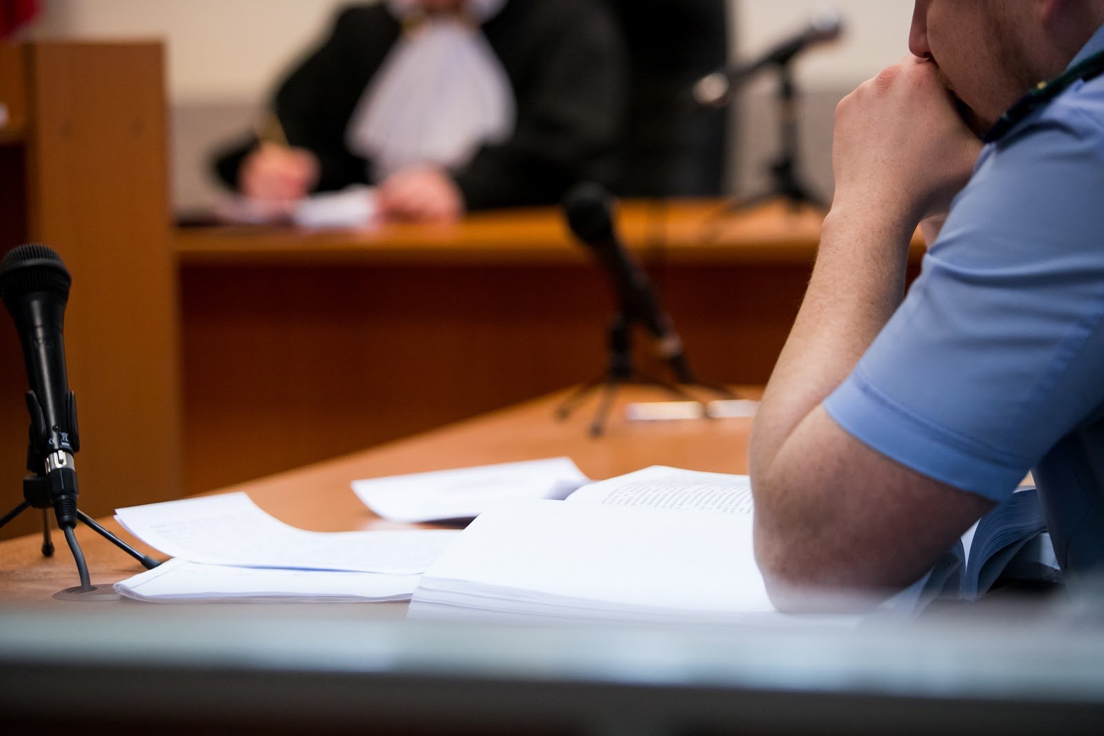 Policeman sitting inside a courtroom
