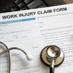Work Injury Claim Form with a pen and a stethoscope