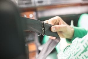 Hand holding a broken seat belt