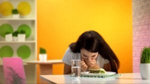 Woman feeling nauseous while eating