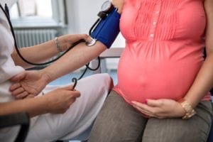 Nurse measuring blood pressure of a pregnant woman