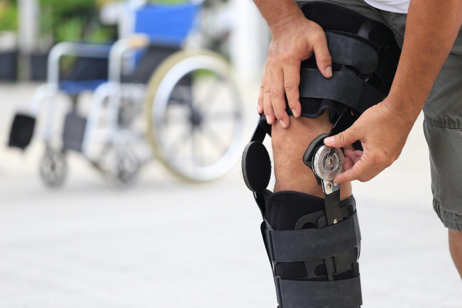 Man wearing a knee brace with a wheelchair in the background