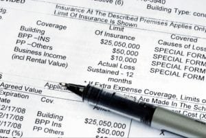 Black pen over a home property insurance policy