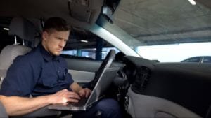 police officer using his laptop inside a car