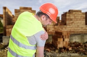 workers compensation shoulder injury settlements: Man holding his shoulder