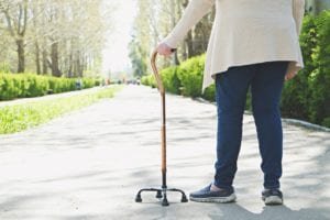 Elderly woman walking in the park with a cane